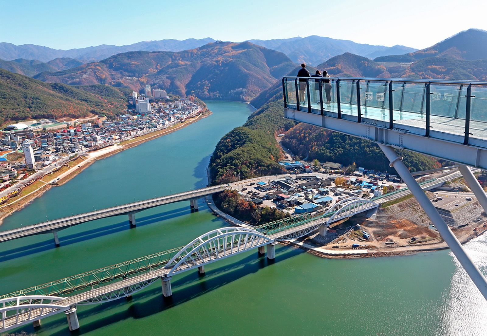 The Mancheonha Skywalk glass walkway jutting over the Namhan River gorge with autumn hills and bridges below