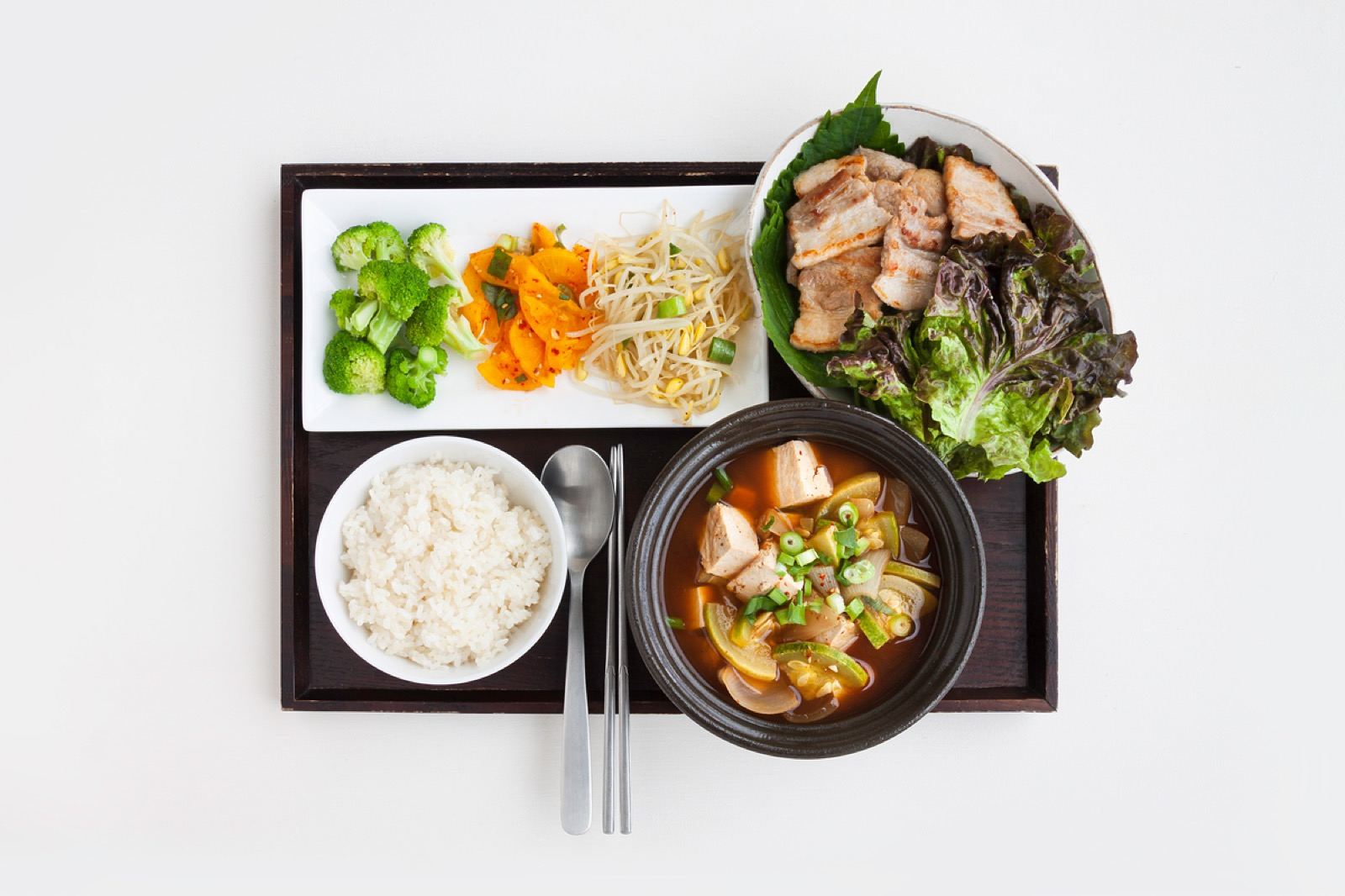 Assorted cuts of meat and side dishes on a Korean BBQ table