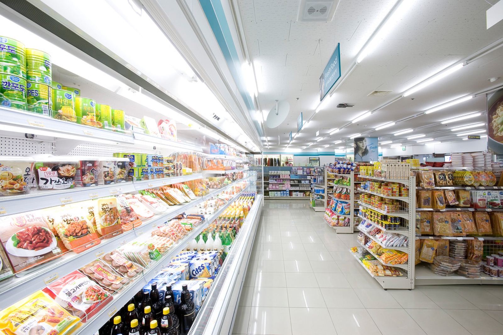 The bright, well-stocked aisles of a Korean convenience store with chilled ready-meals and snacks