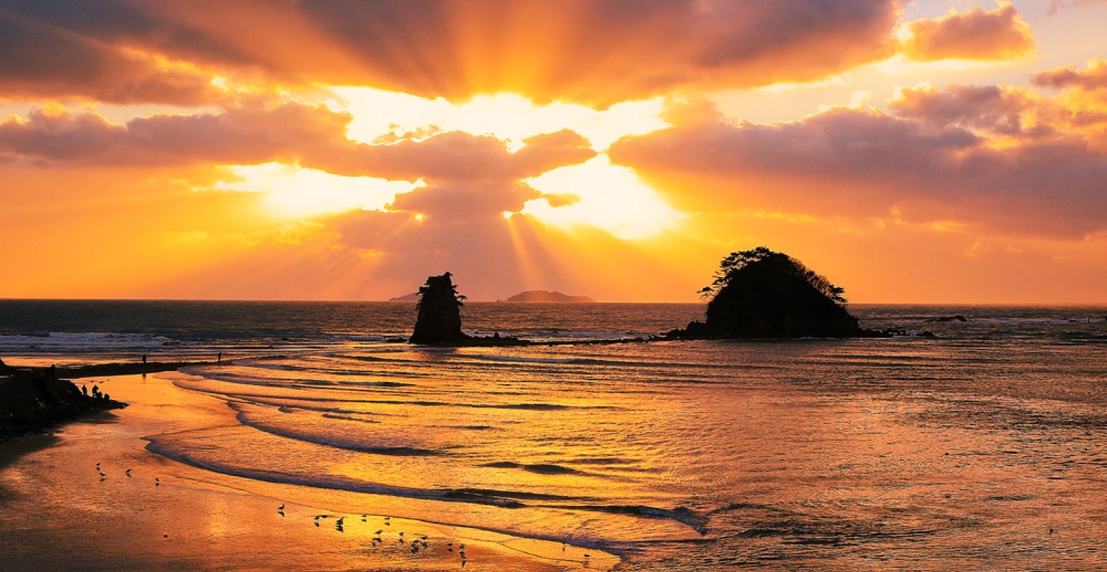 A blazing orange sunset over the sea and twin rock islets at Kkotji Beach in Taean