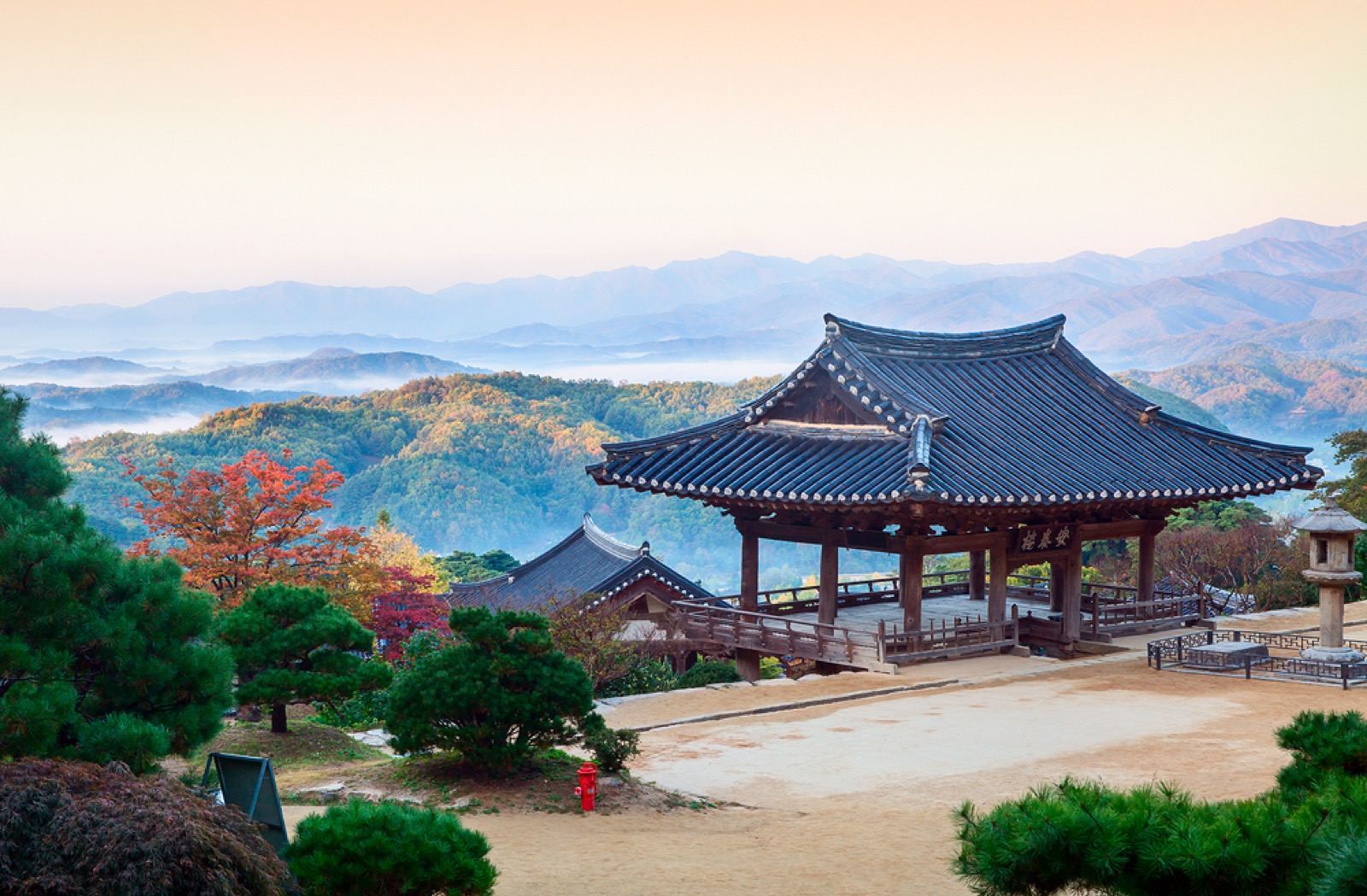 The Anyangnu pavilion at Buseoksa looking out over layered misty mountains at dawn