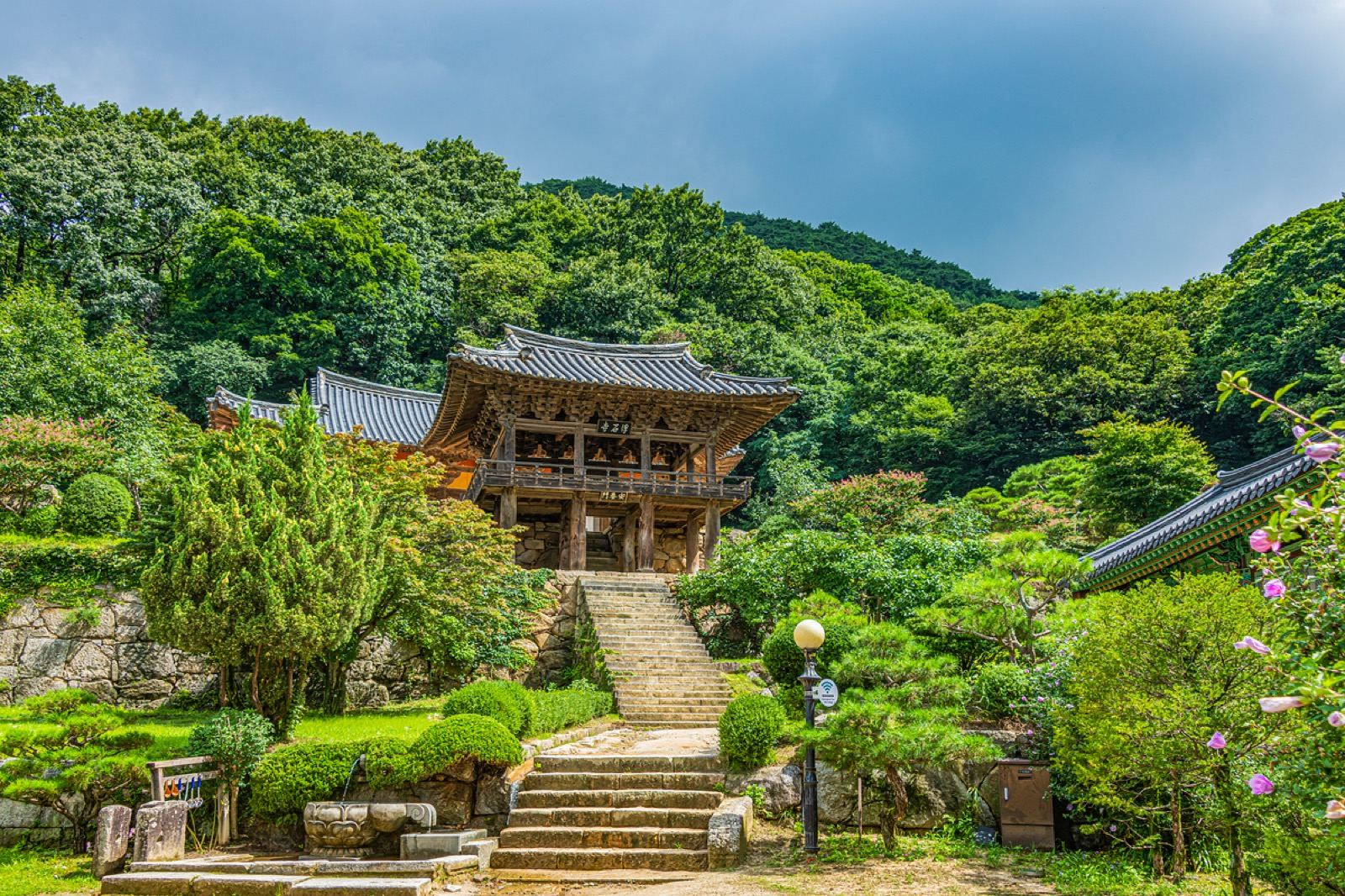 The wooden Beomjongnu bell pavilion and stone staircase at the entrance to Buseoksa temple in summer